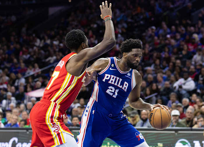76ers center Joel Embiid dribbles past Hawks forward Onyeka Okongwu.